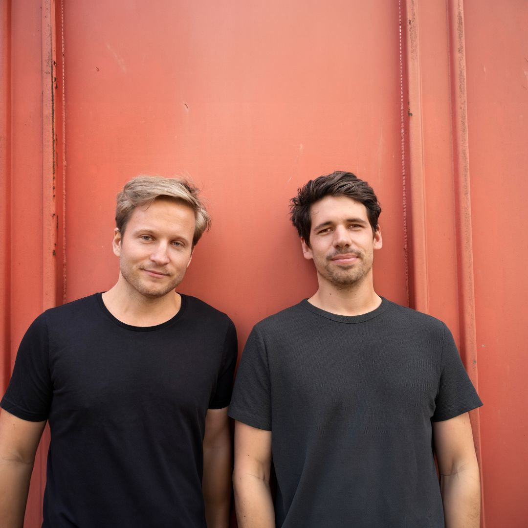 Franziskus und Ferdinand, die Gründer von WYE, vor einer roten Wand